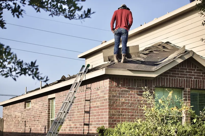 Professional roofer working on a residential roof in Schellsburg
